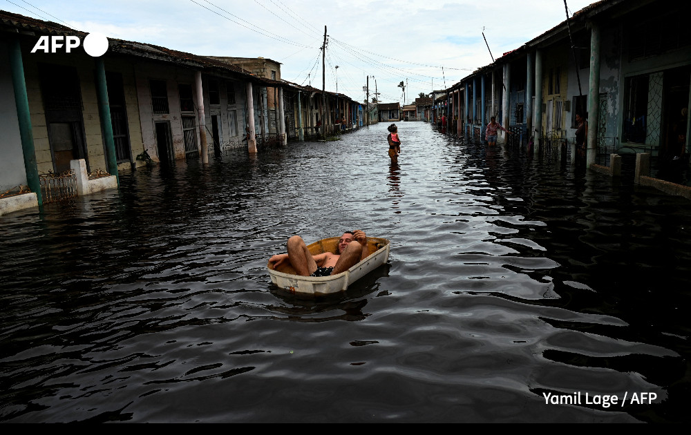 A man rides a handmade raft through a flooded street in Batabano, Mayabeque province, Cuba.